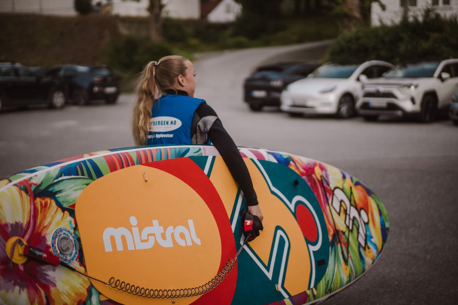 A paddler carrying an inflatable stand up paddle board down to the water